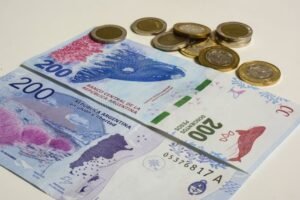 billetes argentinos y reloj de ahorro