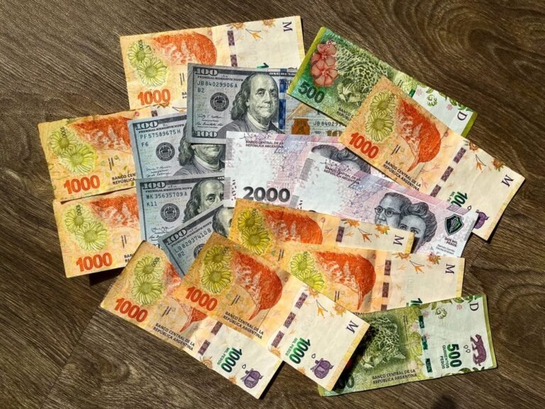 billetes argentinos y reloj sobre mesa moderna