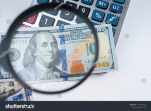 billetes de dolar azul apilados y lupa