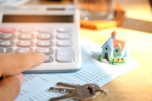 casa con llave y calculadora bancaria