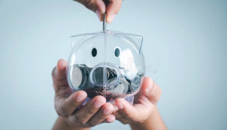 manos guardando monedas en alcancia transparente