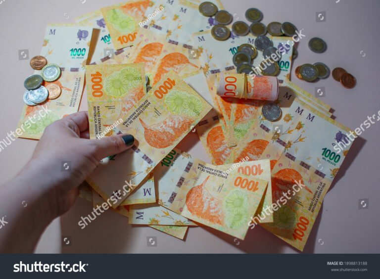 Cuándo cobran los jubilados en diciembre en Argentina 2 manos sosteniendo monedas y billetes argentinos