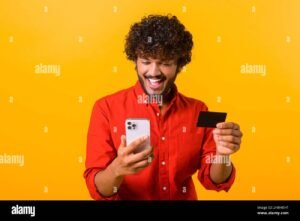 persona pagando con celular y tarjeta naranja 1