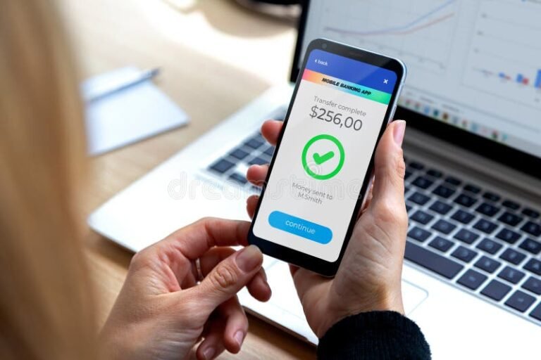persona usando celular y laptop para transferir dinero
