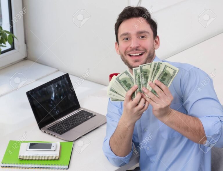 persona usando laptop con billetes dolares al lado