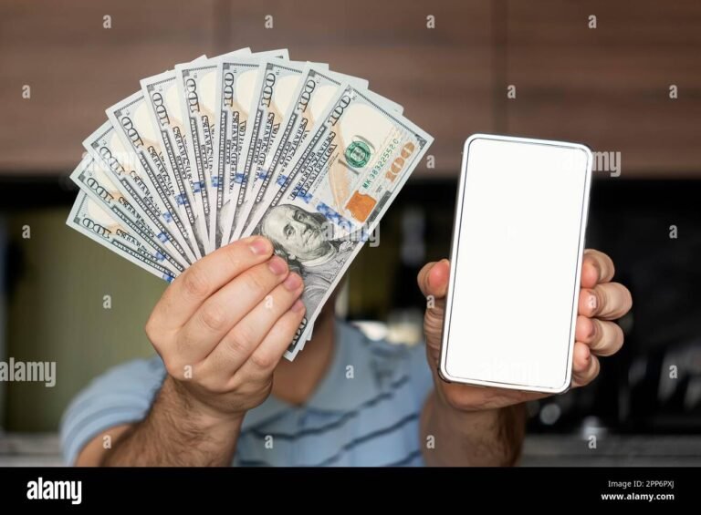 persona usando smartphone con billetes alrededor